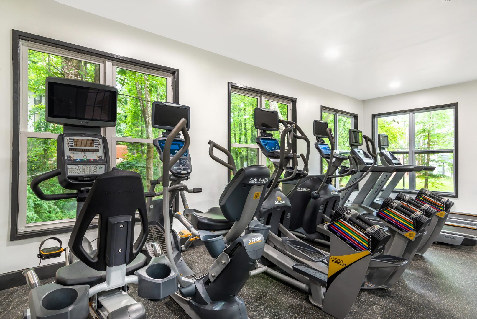 a gym room with tread machines and windows at The  Bowie