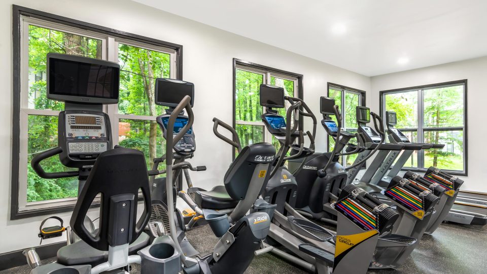 a gym room with tread machines and windows at The  Bowie